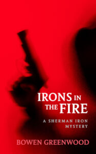 The cover of Irons in the Fire: a shadowy hooded figure holding a gun.